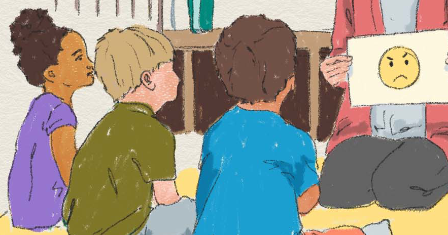 Barn sitter på golvet och tittar på en ledsen emoji på ett papper som någon håller upp