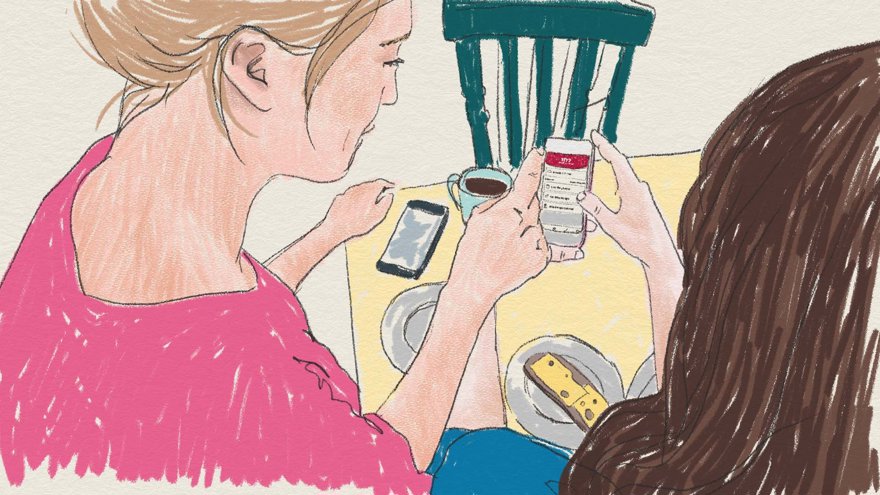 Två personer tittar på en mobiltelefon