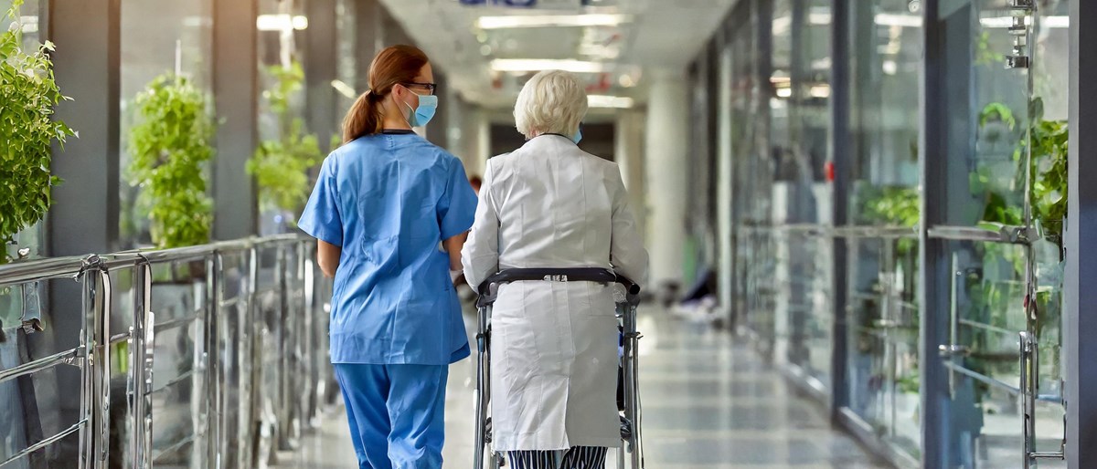 Äldre patient som lämnar sjukhus som får hjälp av vårdpersonal