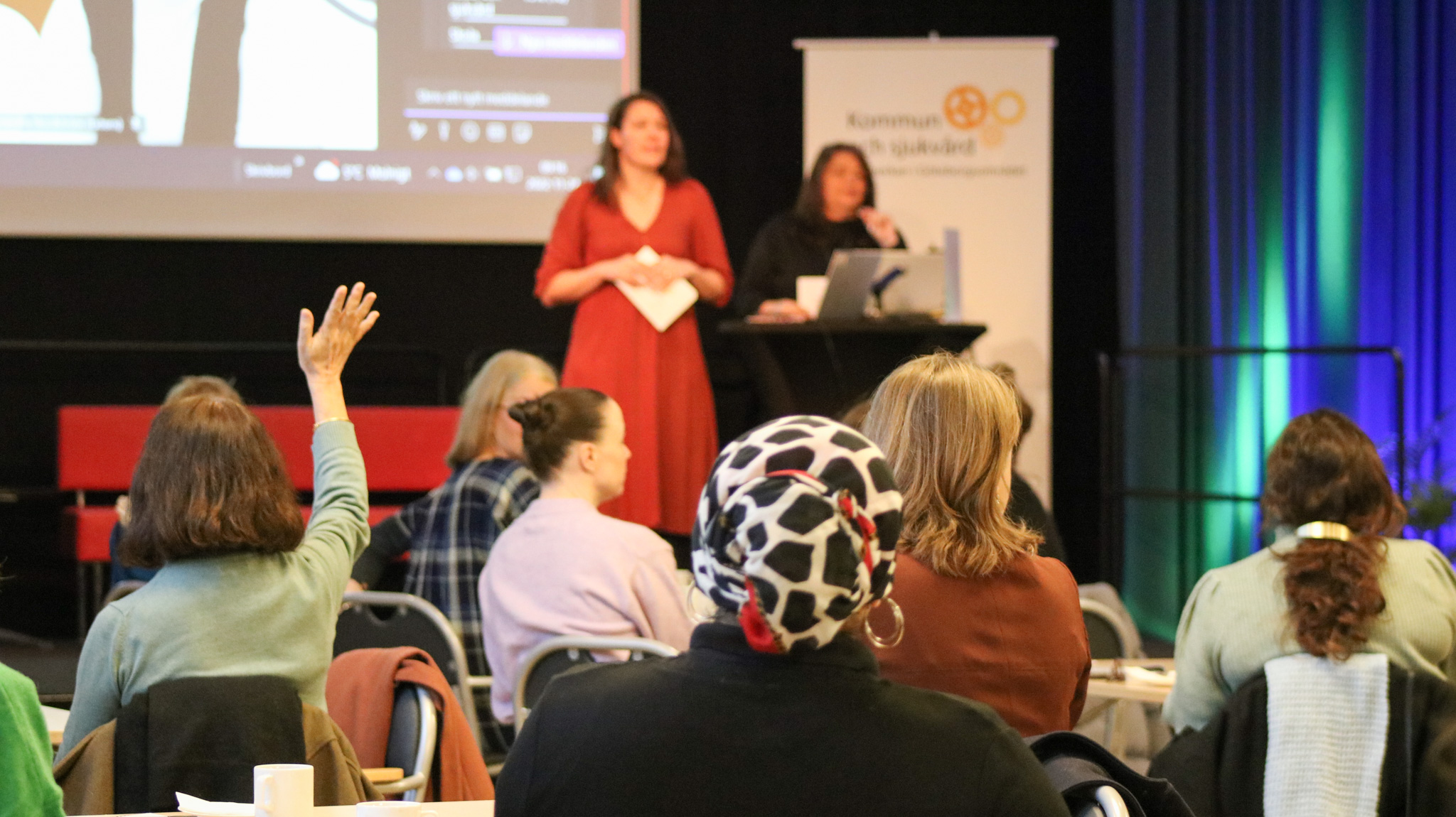 Kvinna räcker upp handen i publiken