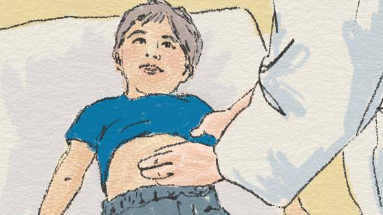 Ett barn ligger på en brits och en läkare undersöker barnets mage