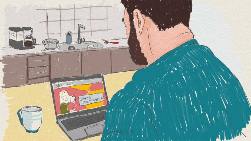 En man sitter framför sin bärbara dator i ett kök