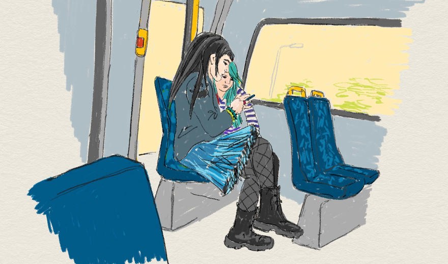 Två ungdomar tittar på en telefon i en buss