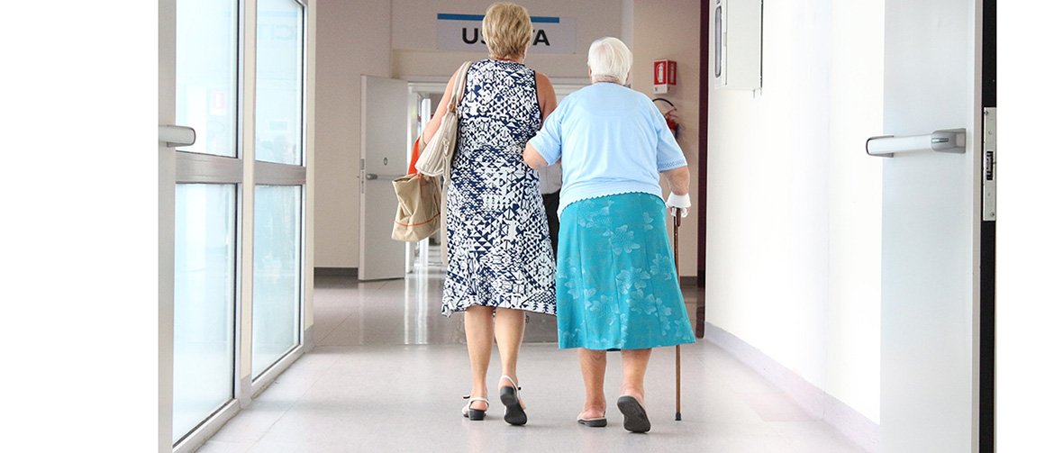 Två kvinnor går bortåt i sjukhusmiljö
